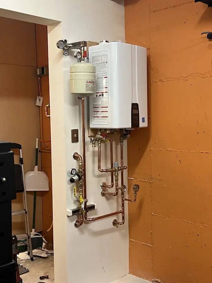Plumbing technician inspecting water heater connections in Middleborough